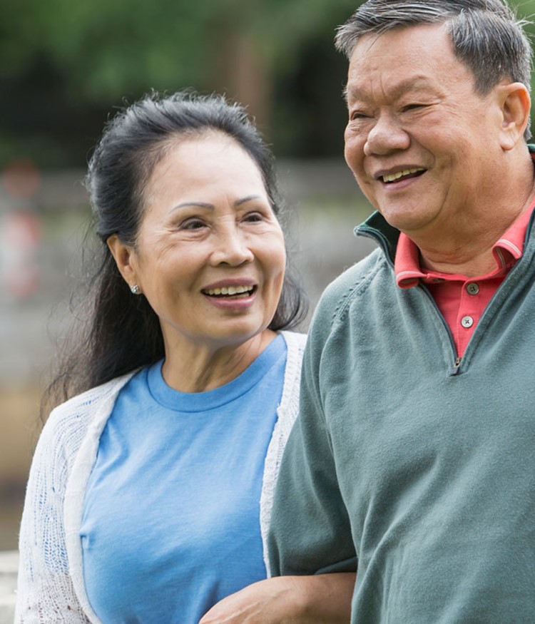 Happy Senior Couple Walking In Park