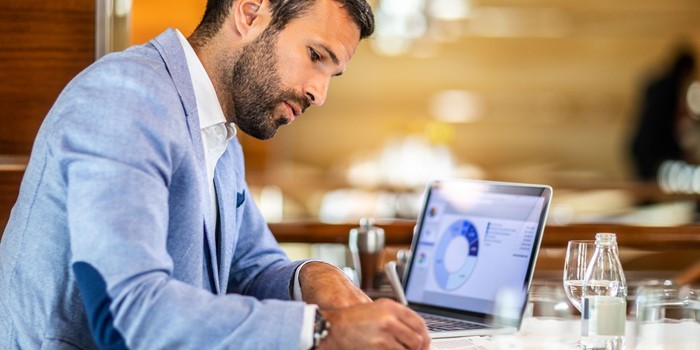 Man Writing On A Document While Sitting In A Restaurant