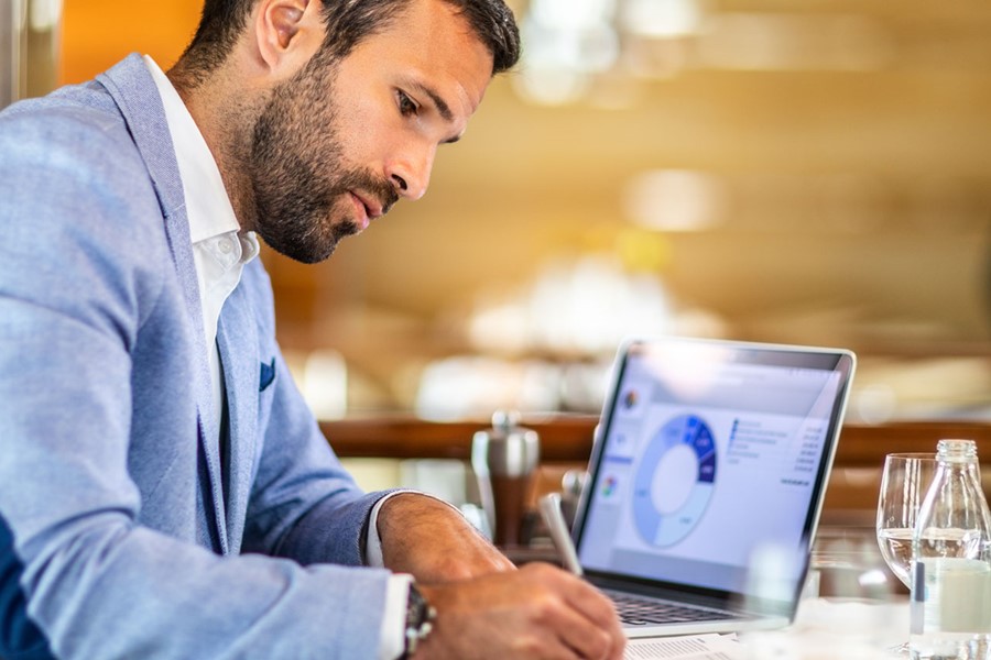 Man Writing On A Document While Sitting In A Restaurant
