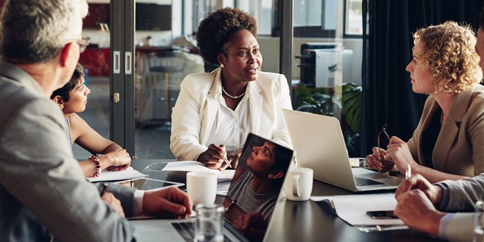 Businesspeople Discussing Work Together Around A Boardroom Table