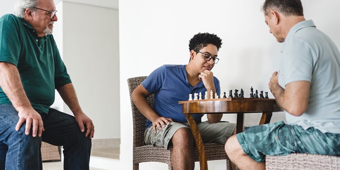 Men Of Three Generations During A Game Of Chess