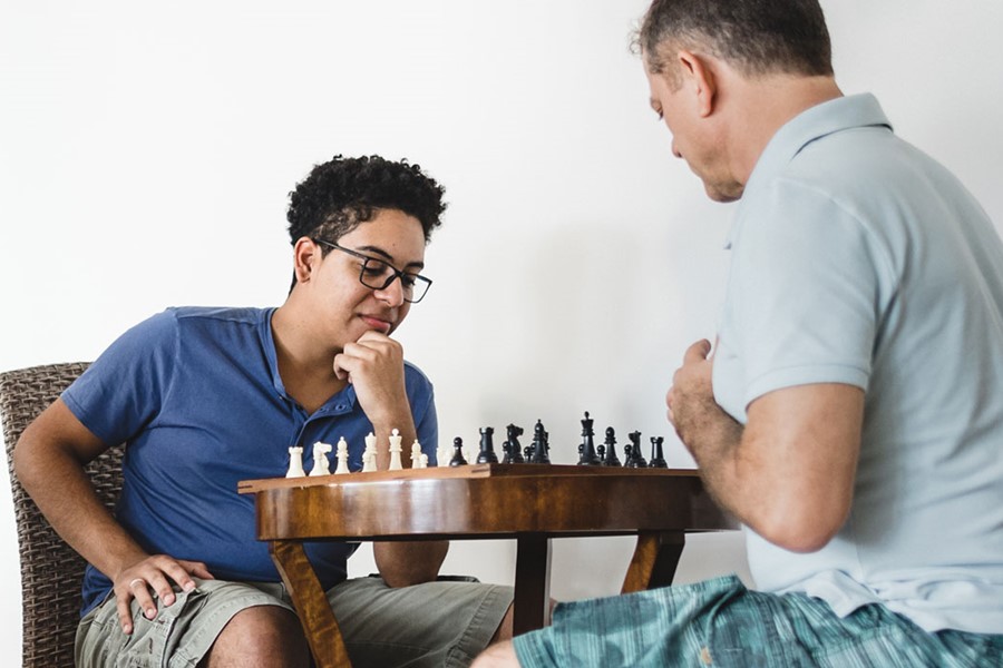 Men Of Three Generations During A Game Of Chess