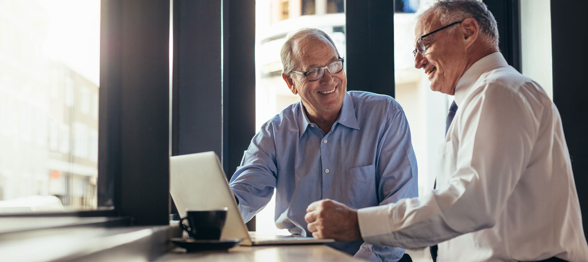 Two Business Men Working Together In Modern Cafe