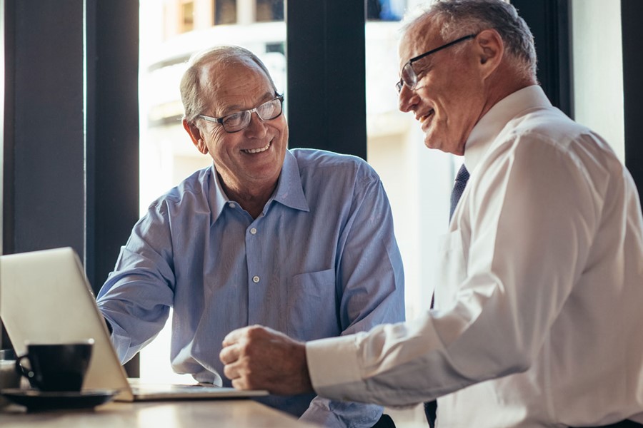 Two Business Men Working Together In Modern Cafe
