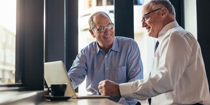Two Business Men Working Together In Modern Cafe