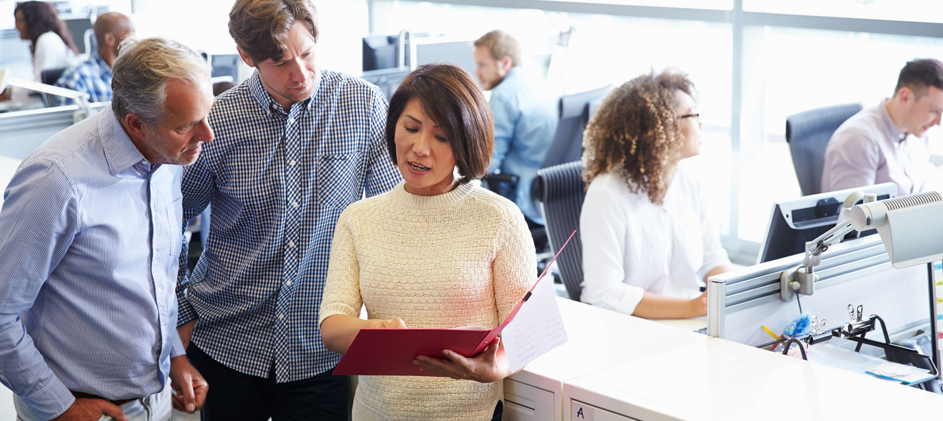 Staff Standing In A Busy Open Plan Office