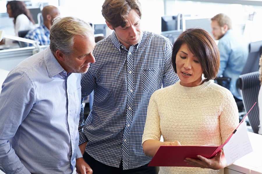 Staff Standing In A Busy Open Plan Office