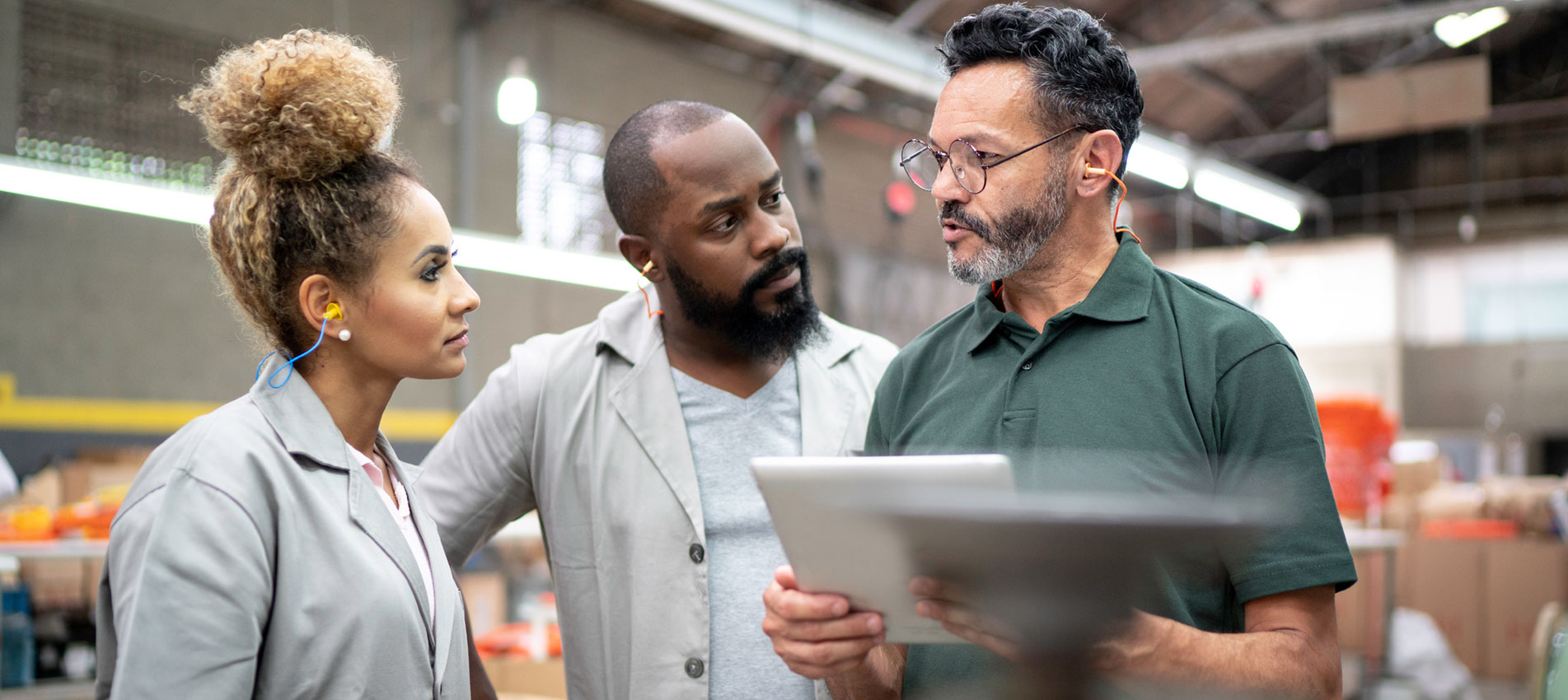 Showing Something In A Digital Tablet To His Employees In A Factory