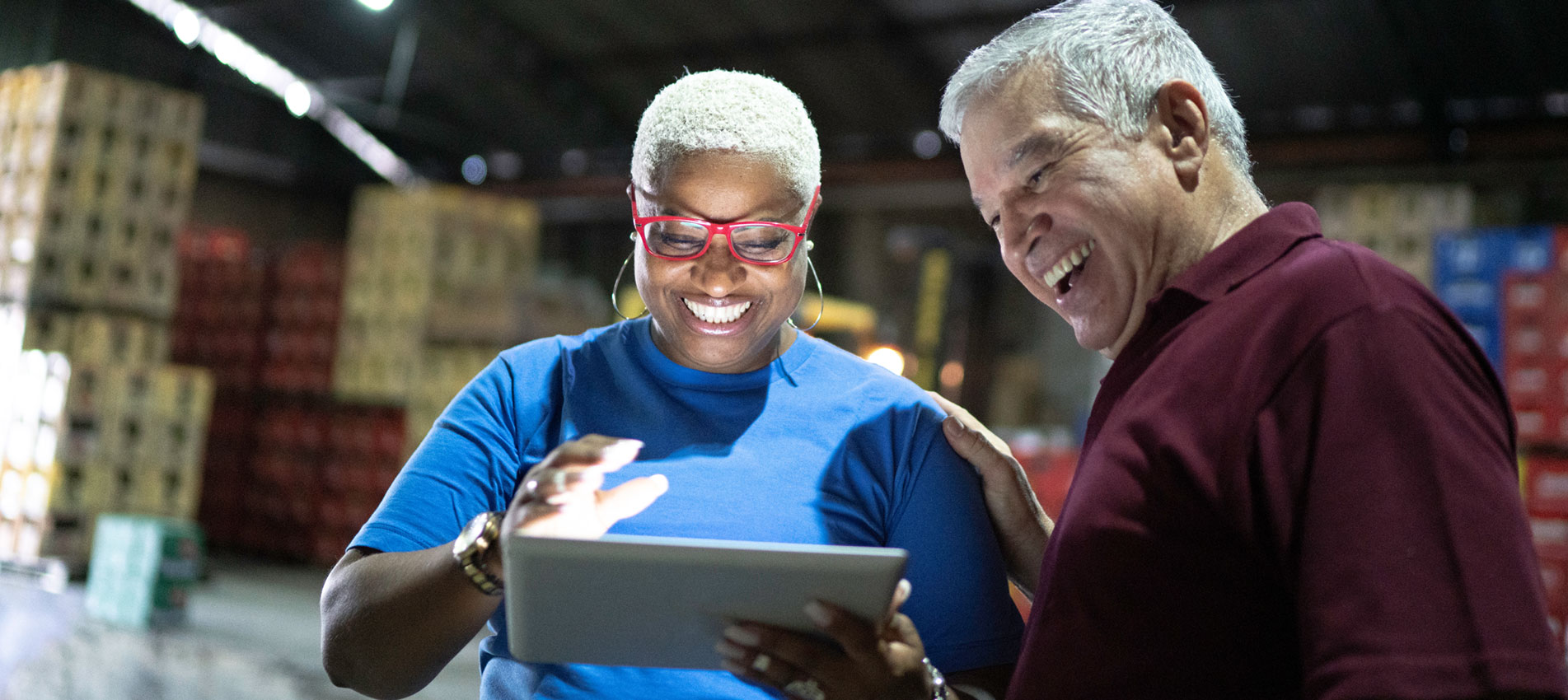 Partners Celebrating Good News And Using Digital Tablet At Warehouse
