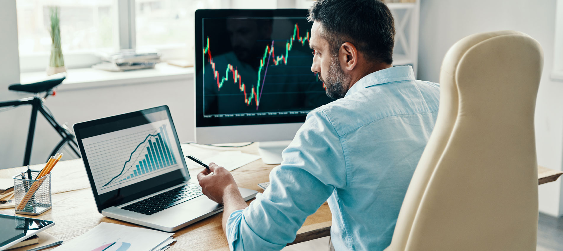 Rear View Of Man In Smart Casual Wear Analyzing Stock Market Data