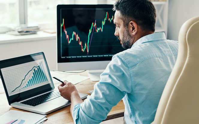 Rear View Of Man In Smart Casual Wear Analyzing Stock Market Data