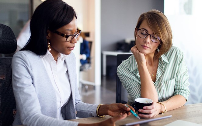 Businesswomen Analyzing Graph With Digital Tablet