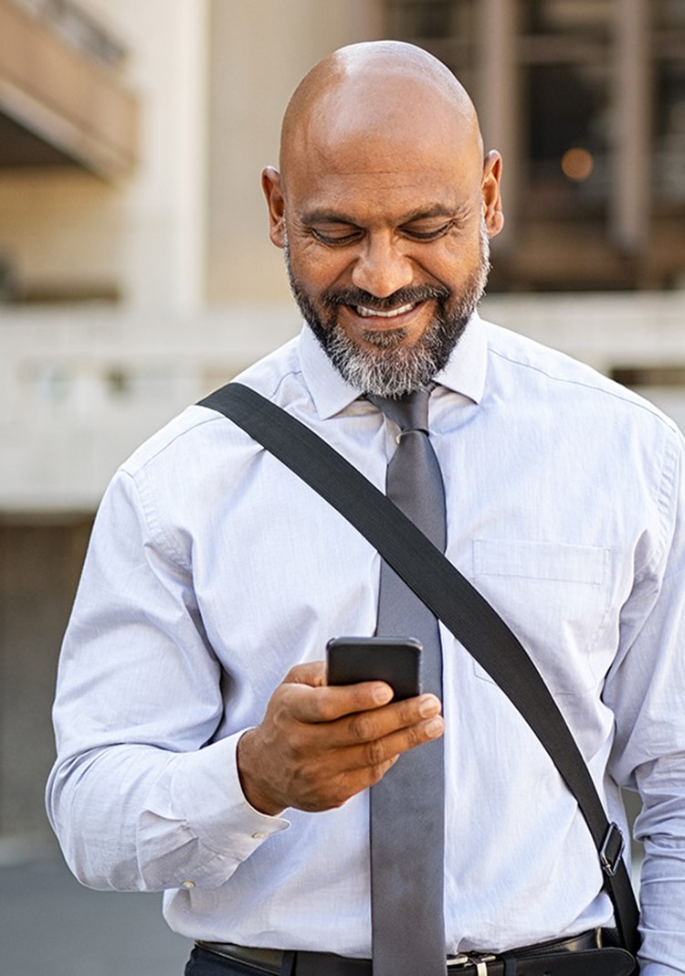 African American Satisfied Businessman Walking While Using Phone