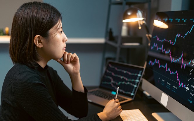 Young Woman Doing Cryptocurrency Business Trading On Her Computer At Home At Nigh (1)