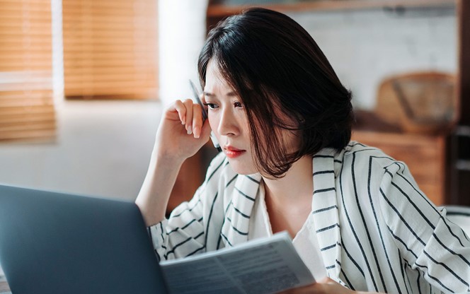 Asian Businesswoman Looking Worried While Going Through Finances