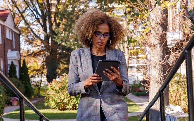 African American Real Estate Agent, Using Her Tablet To Check The Information About The House