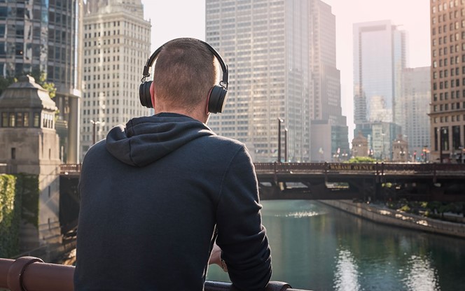 Pensive Man With Wireless Headphones During City Walk