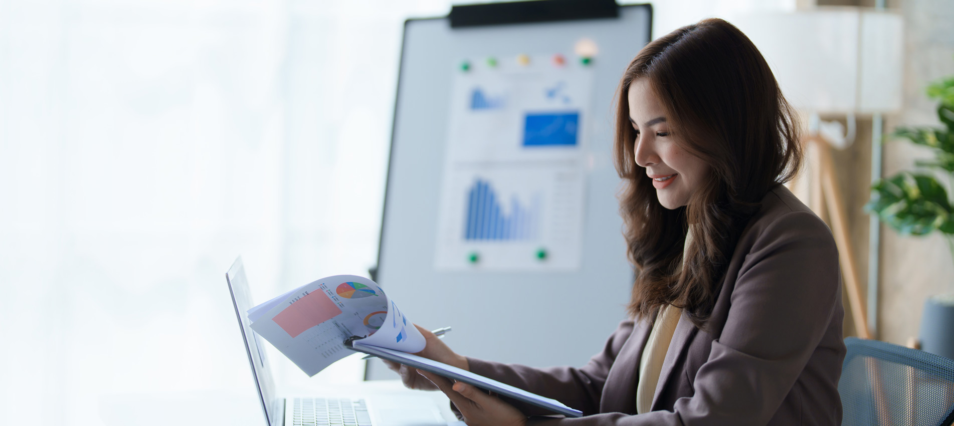 Businesswoman Working On Calculator And Laptop Calculating Data At The Office