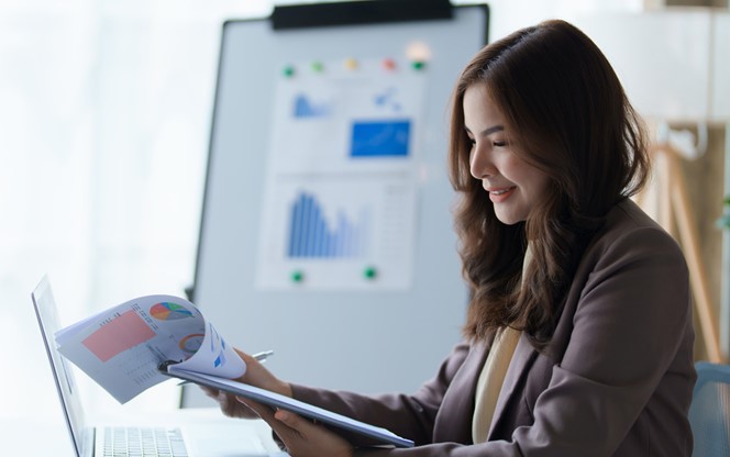 Businesswoman Working On Calculator And Laptop Calculating Data At The Office