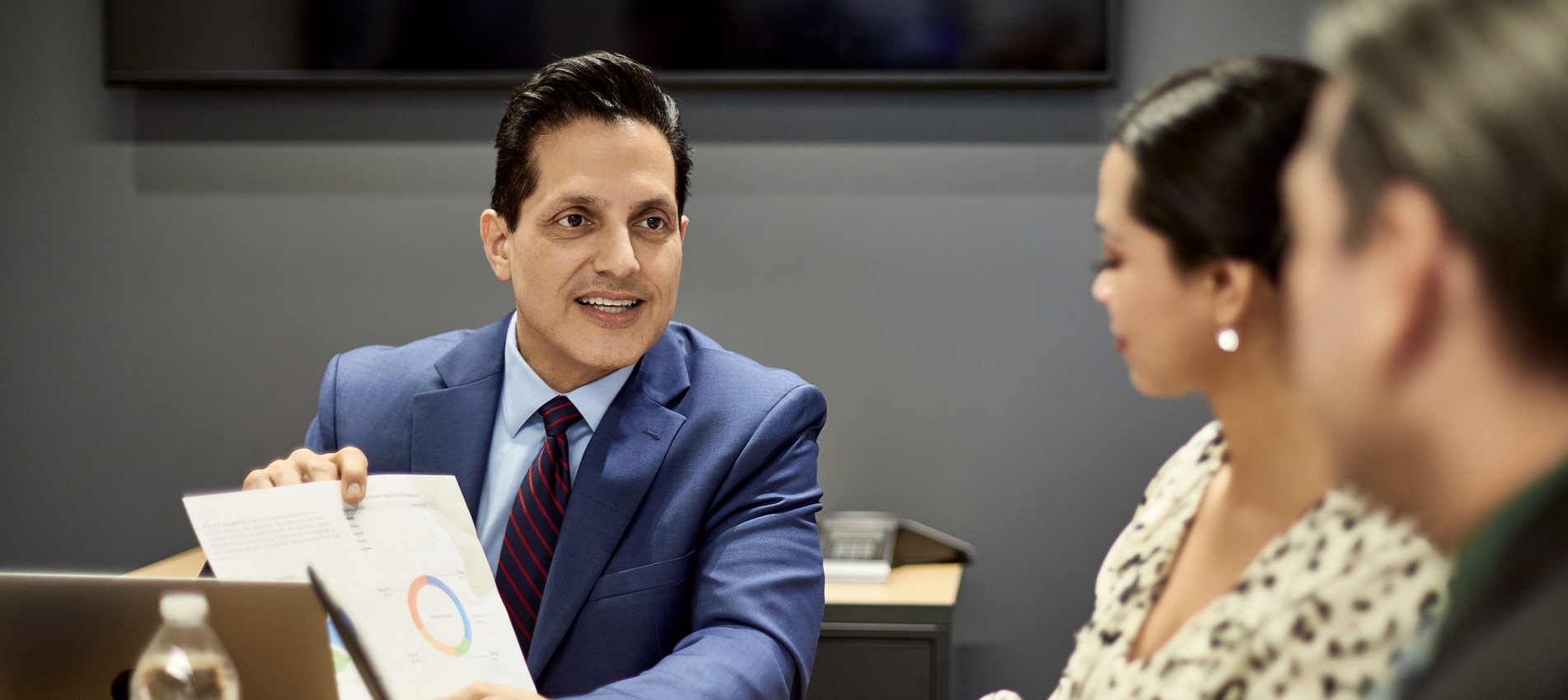 Hispanic Project Manager Showing Infographic To Colleagues