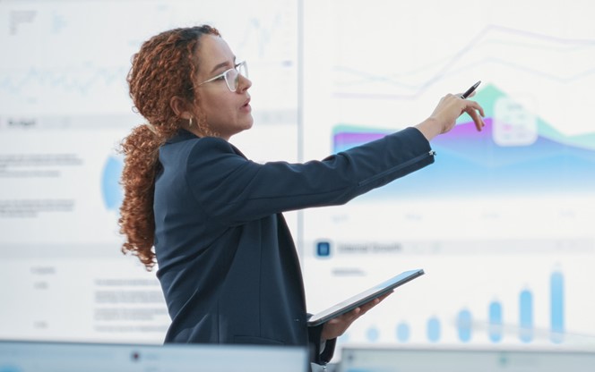 Hispanic Female Data Analyst Reviewing Market Reports