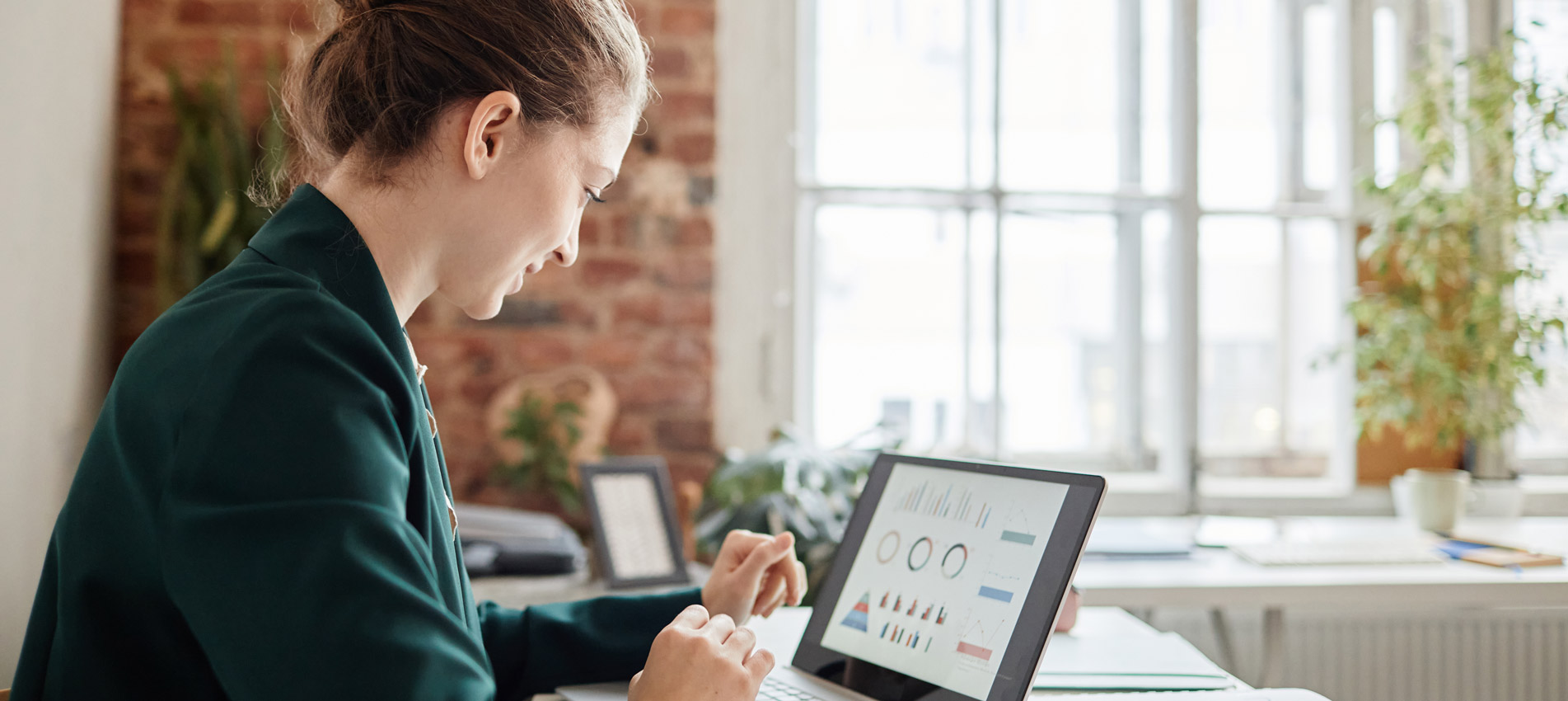 Female Accountant Looking At Financial Data On Laptop Screen