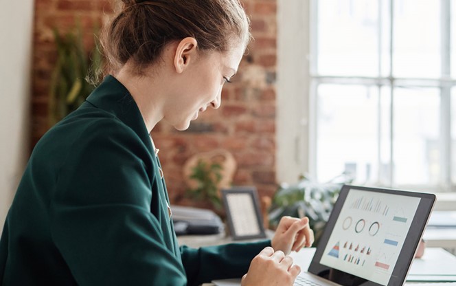 Female Accountant Looking At Financial Data On Laptop Screen
