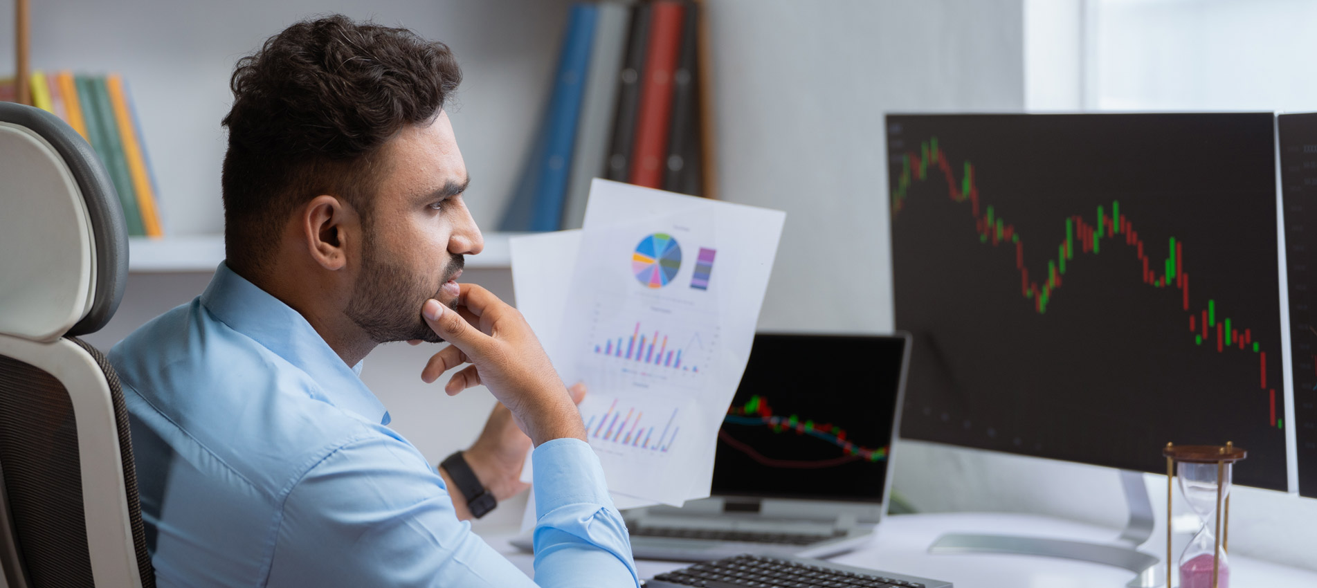 Businessman Analyzing Data On Paper And Screen