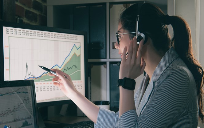 Young Businesswoman Review Market Graphs On Screen