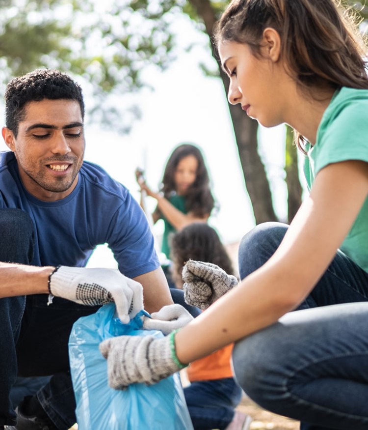 Colleagues Picking Up Garbage To Clean A Public Park