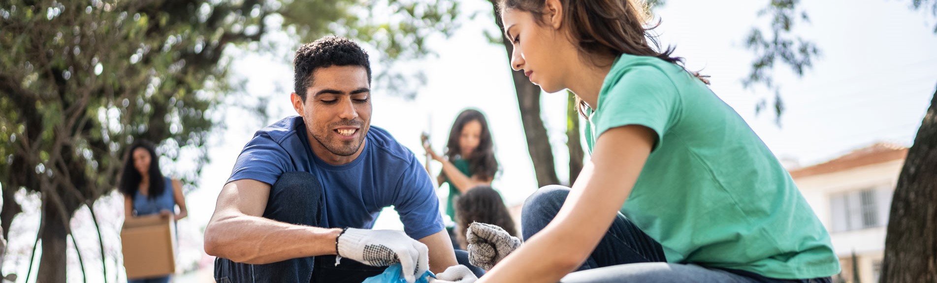Colleagues Picking Up Garbage To Clean A Public Park