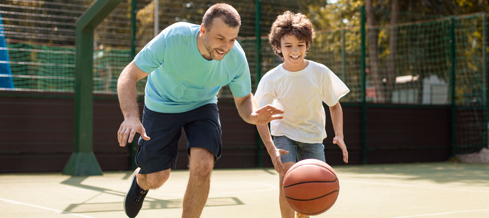 Dad Teaching His Son How To Play Basketball