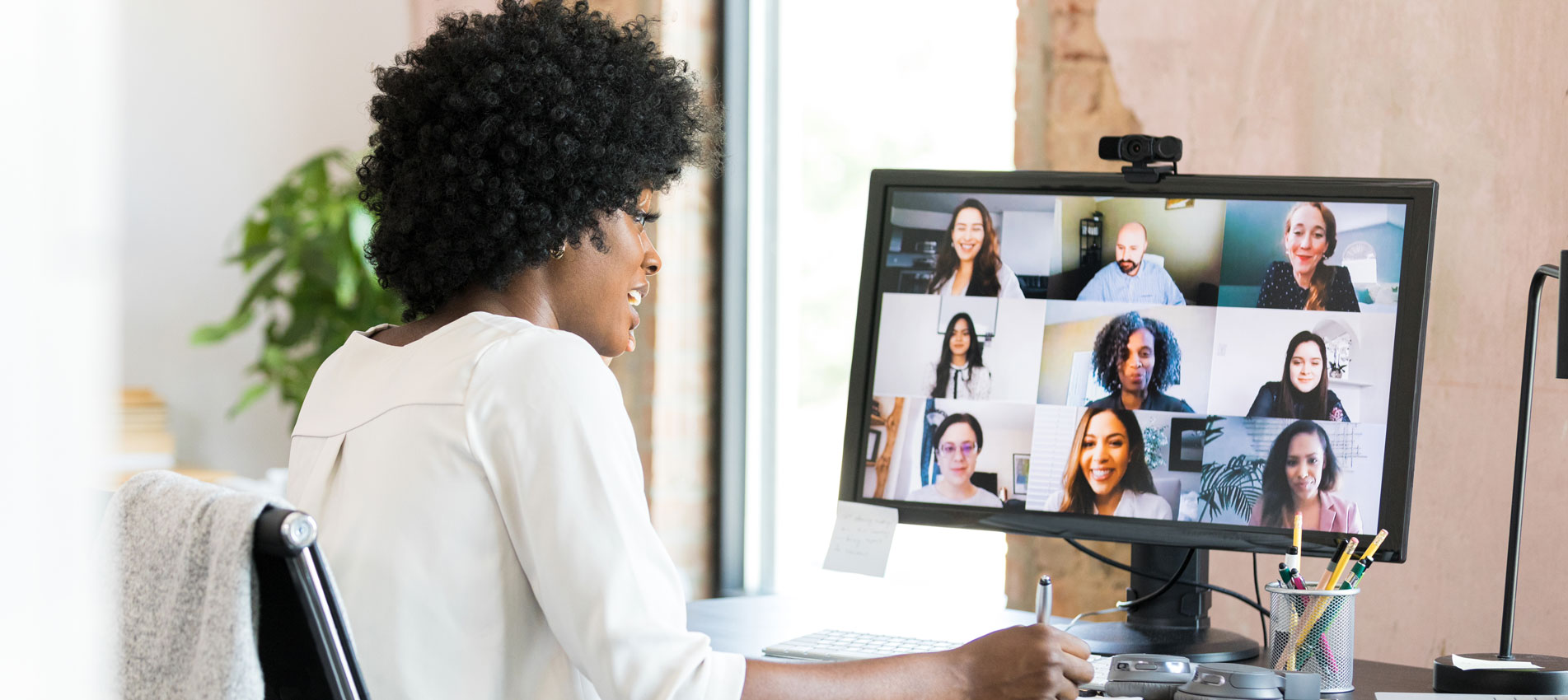 Female Businesswoman Takes Notes During A Video Conference With Her Colleagues