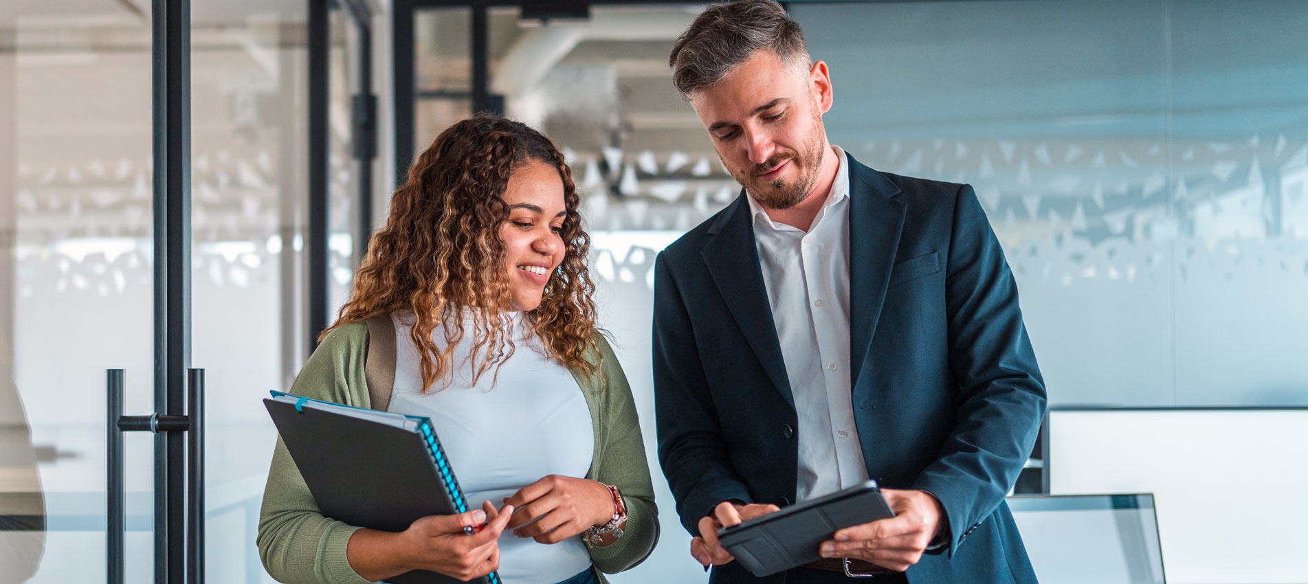 Male And Female Business Colleagues Collaborate Using A Tablet