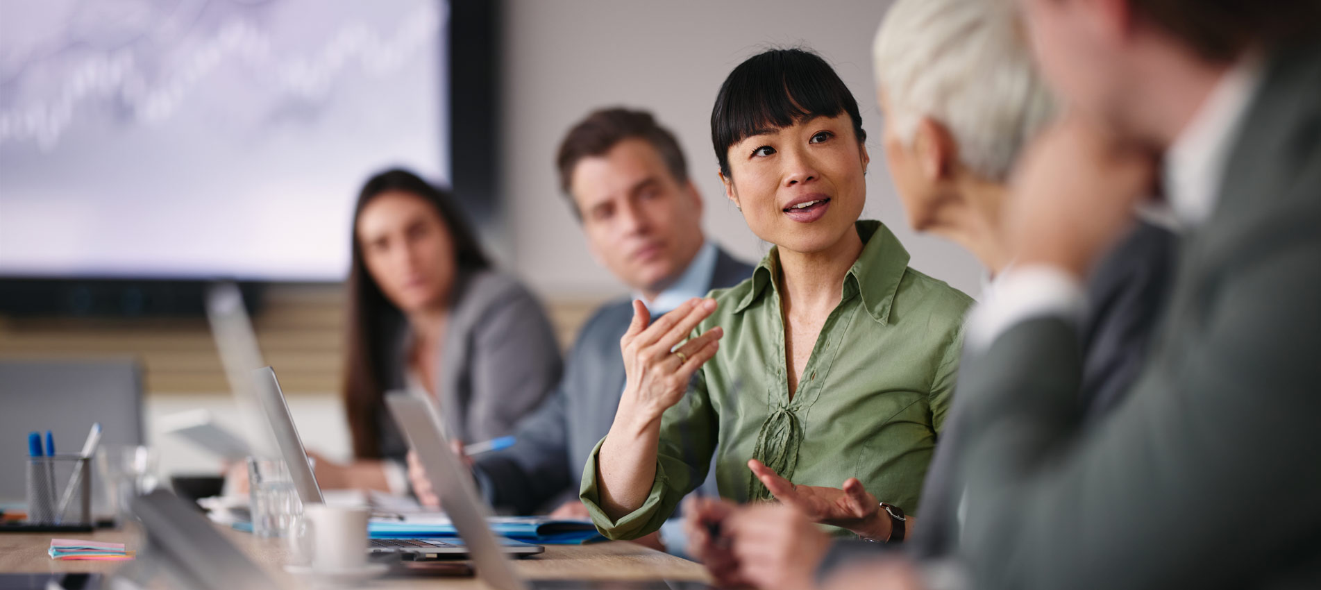 Happy Asian Businesswoman Talking To Her Colleague In The Office