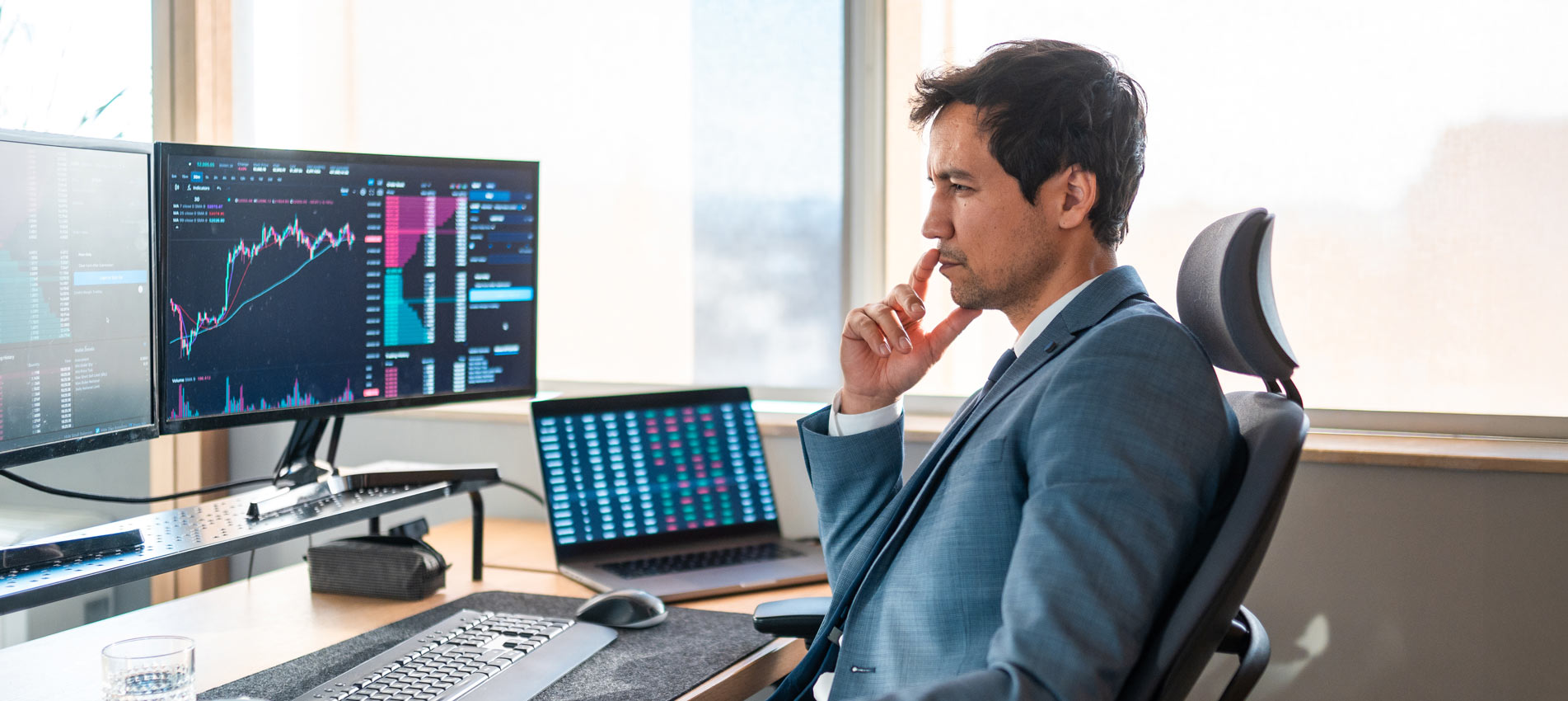 Asian Male Stockbroker Focused On The Screen In Office