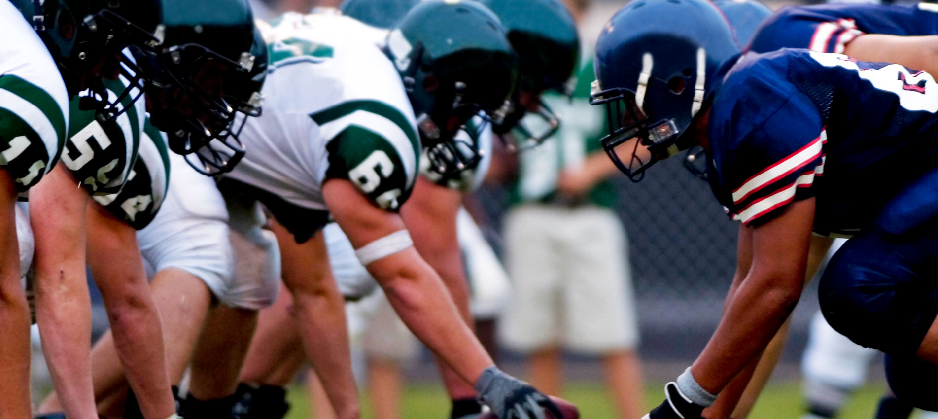 American Football Players At Line Of Scrimmage During Football Game